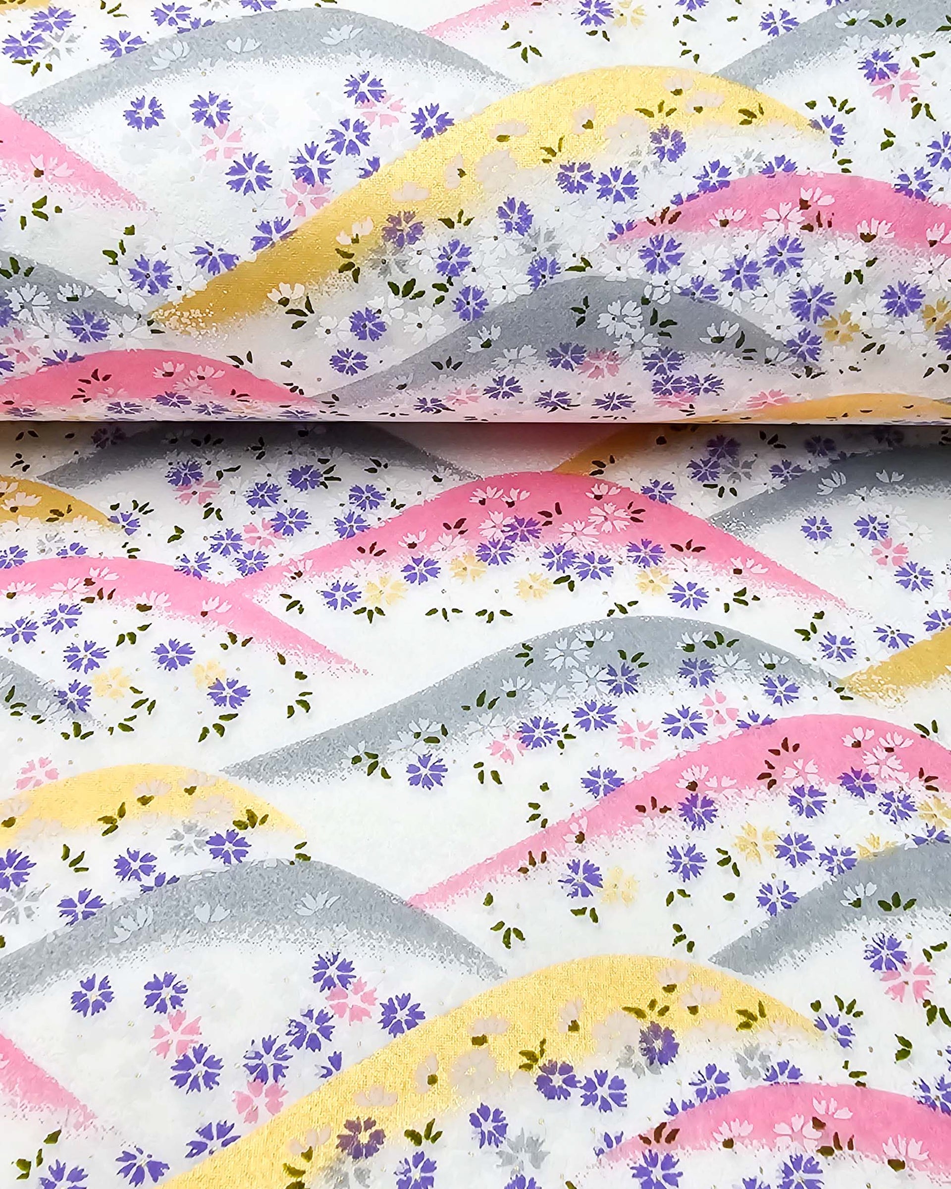 Japanese chiyogami paper featuring pink, gray, and gold hills with purple, pink, and white cherry blossoms on a white background with metallic gold accents.