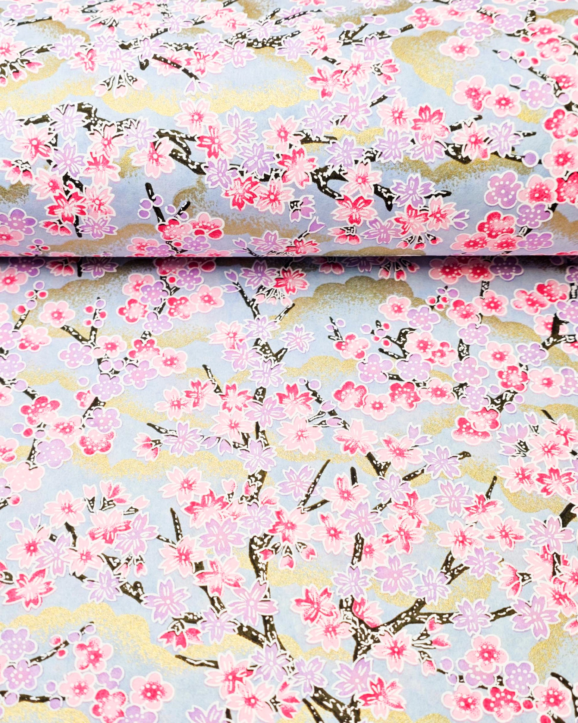 Japanese chiyogami featuring pink & purple cherry & plum blossoms on a blue background with metallic gold accents.