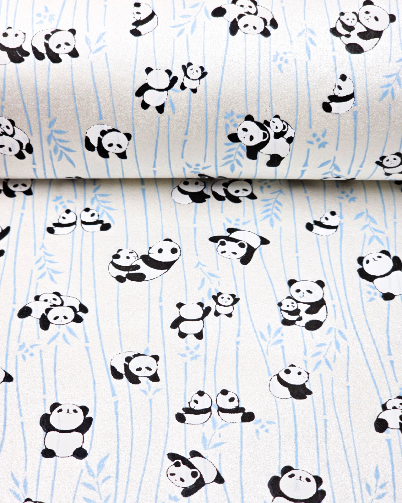Japanese chiyogami paper featuring black & white pandas with blue bamboo on a pearlescent white background.