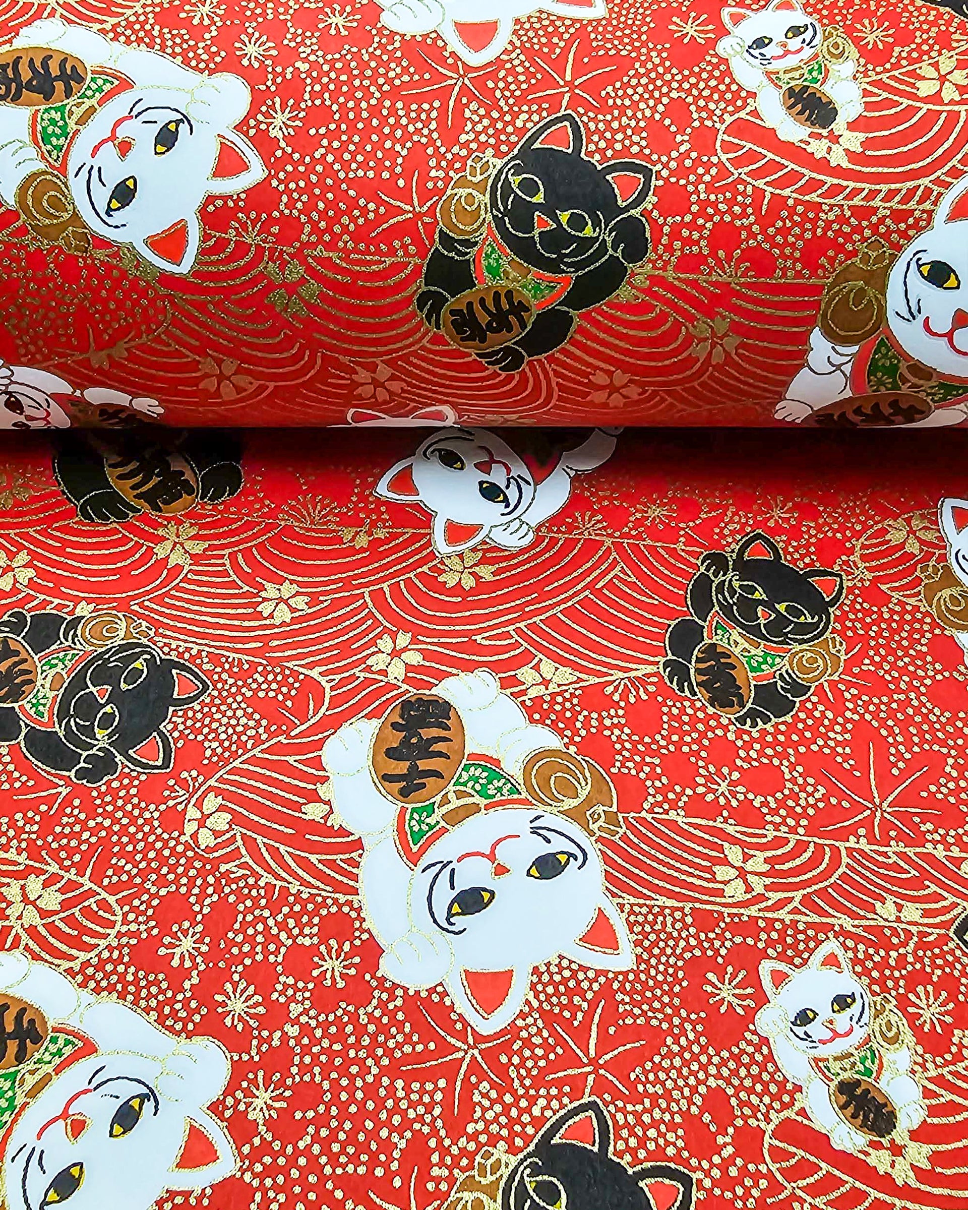 Japanese chiyogami paper featuring black & white lucky cats on a red background with metallic gold accents.