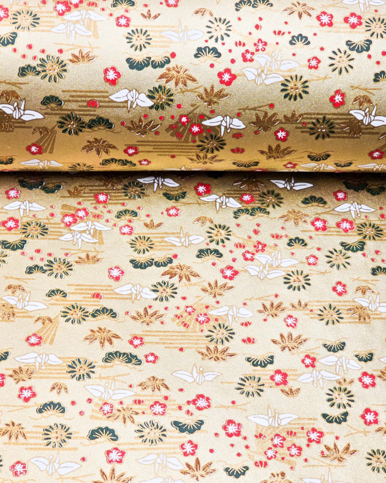 Japanese chiyogami featuring white origami cranes with green plants and red plum blossoms on a metallic gold background.