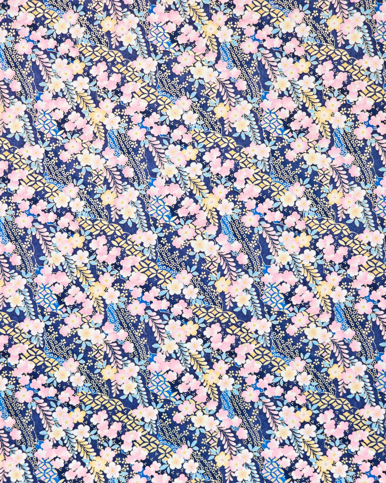 Japanese chiyogami paper featuring pink & yellow plum blossoms with blue, pink, and yellow wisteria on a dark blue back ground with  metallic gold accents.