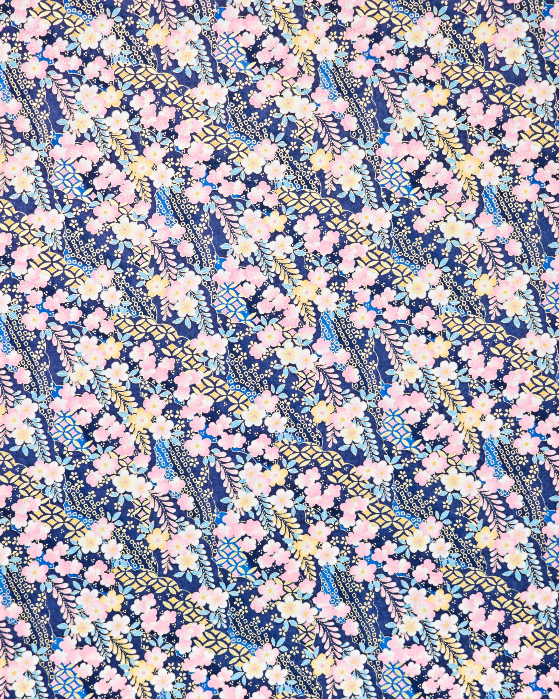 Japanese chiyogami paper featuring pink & yellow plum blossoms with blue, pink, and yellow wisteria on a dark blue back ground with  metallic gold accents.