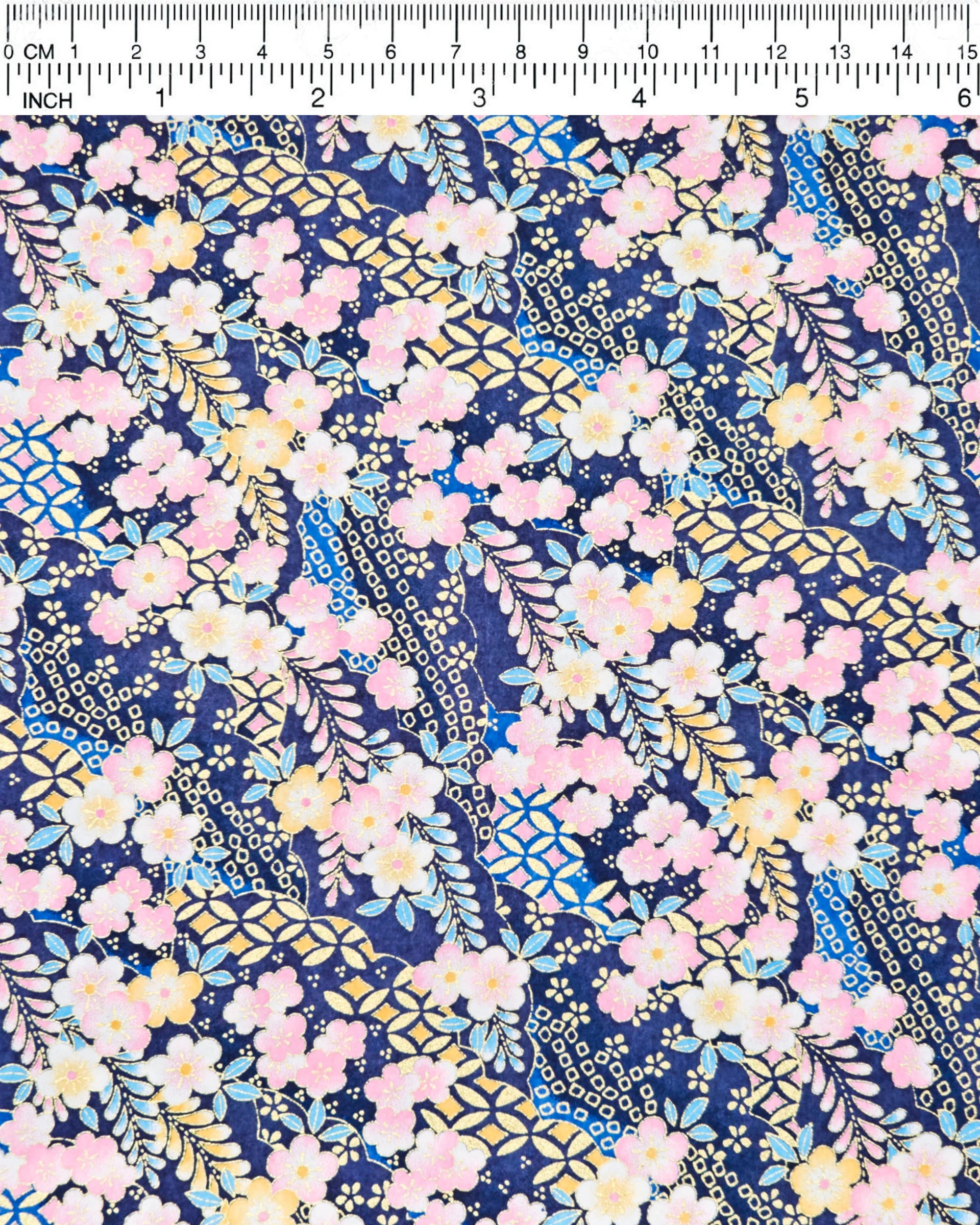 Japanese chiyogami paper featuring pink & yellow plum blossoms with blue, pink, and yellow wisteria on a dark blue back ground with  metallic gold accents.