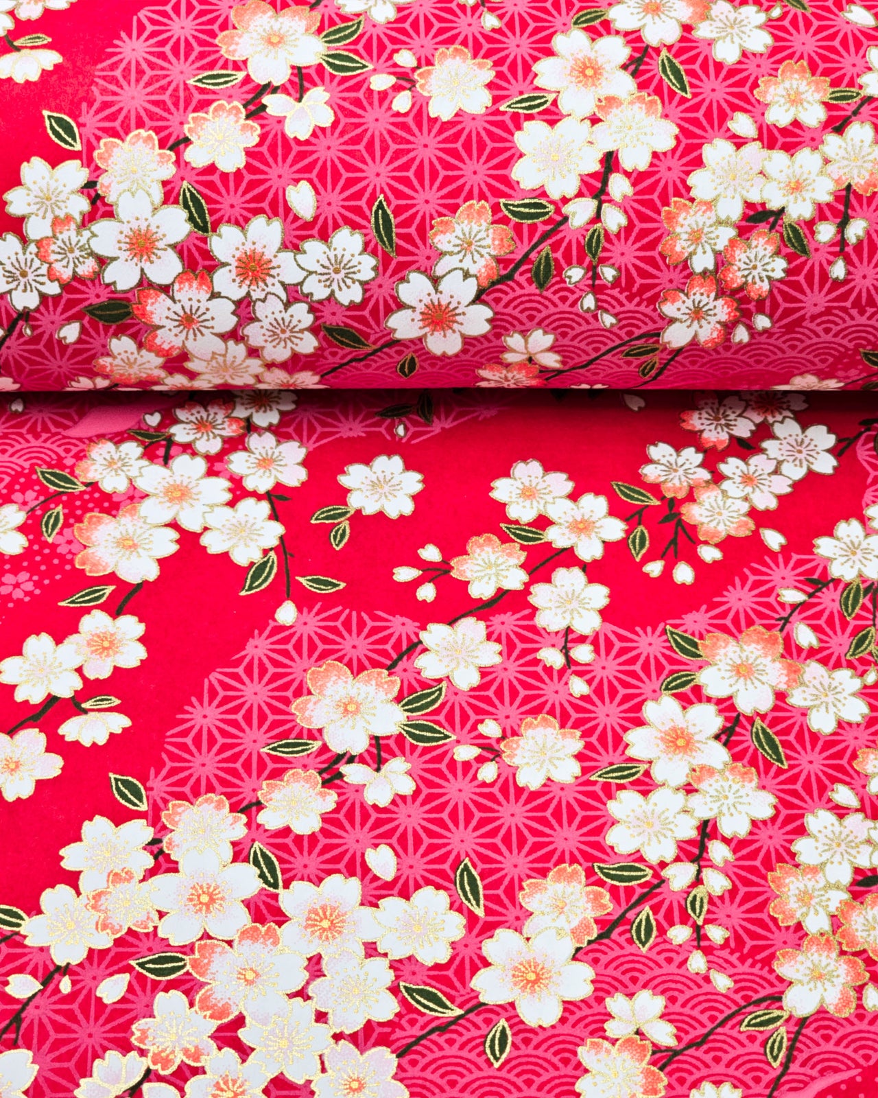 Japanese chiyogami paper featuring pink & white cherry blossoms on a red background with metallic gold accents.