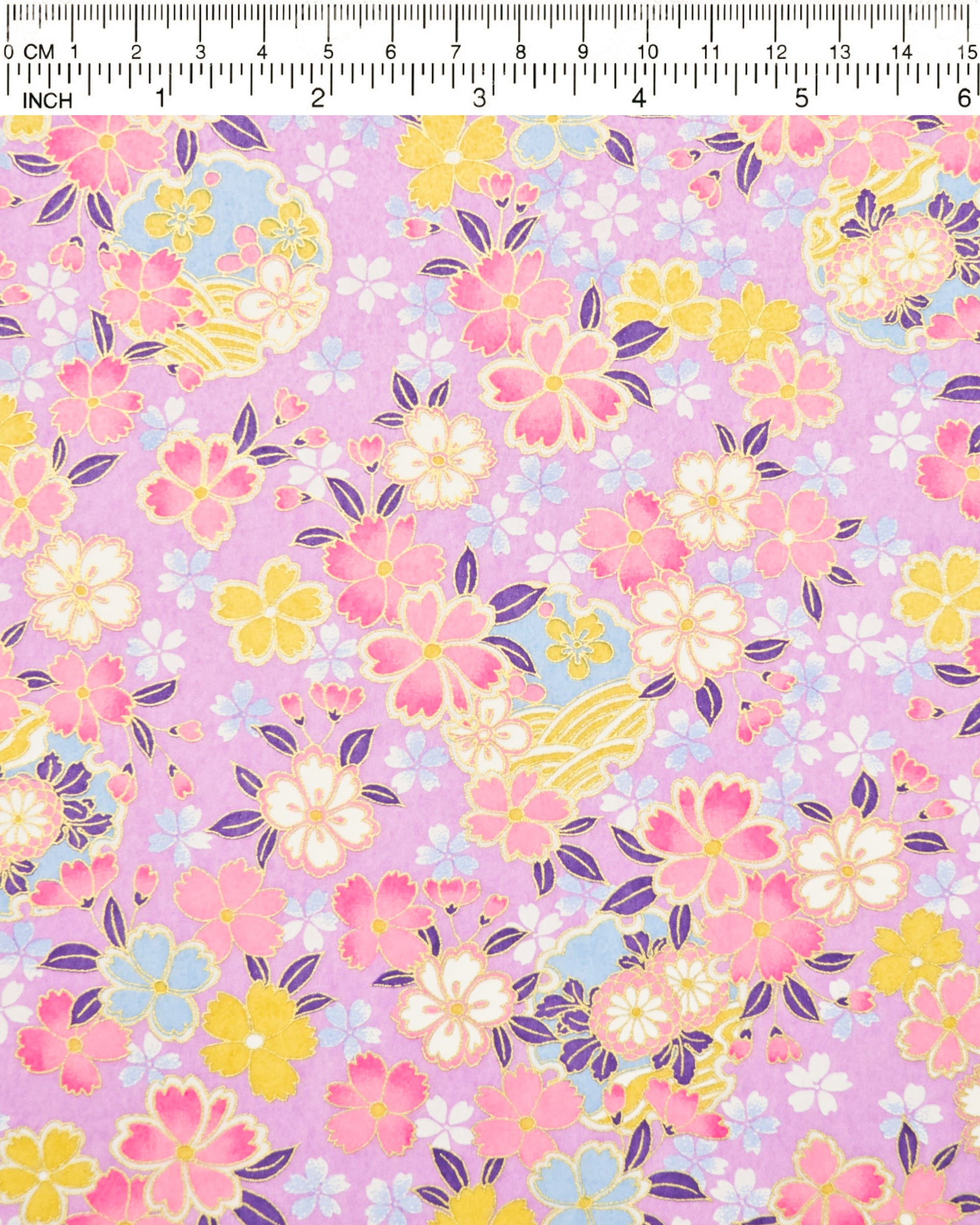 Japanese chiyogami paper featuring pink, yellow, blue, and white cherry blossoms and purple yukiwas on a purple background with metallic gold accents.