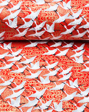 Japanese chiyogami paper featuring white flying cranes on an red background with metallic gold accents.