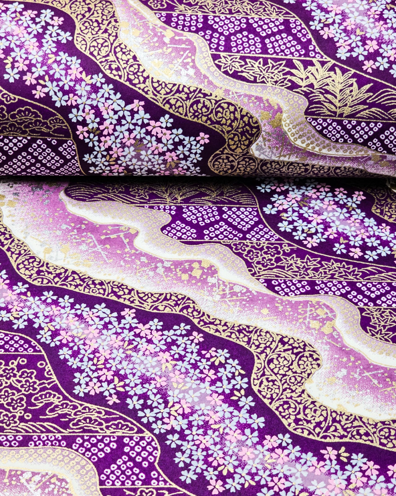 Japanese chiyogami paper featuring pink & white cherry blossoms on purple background with metallic gold & silver accents.