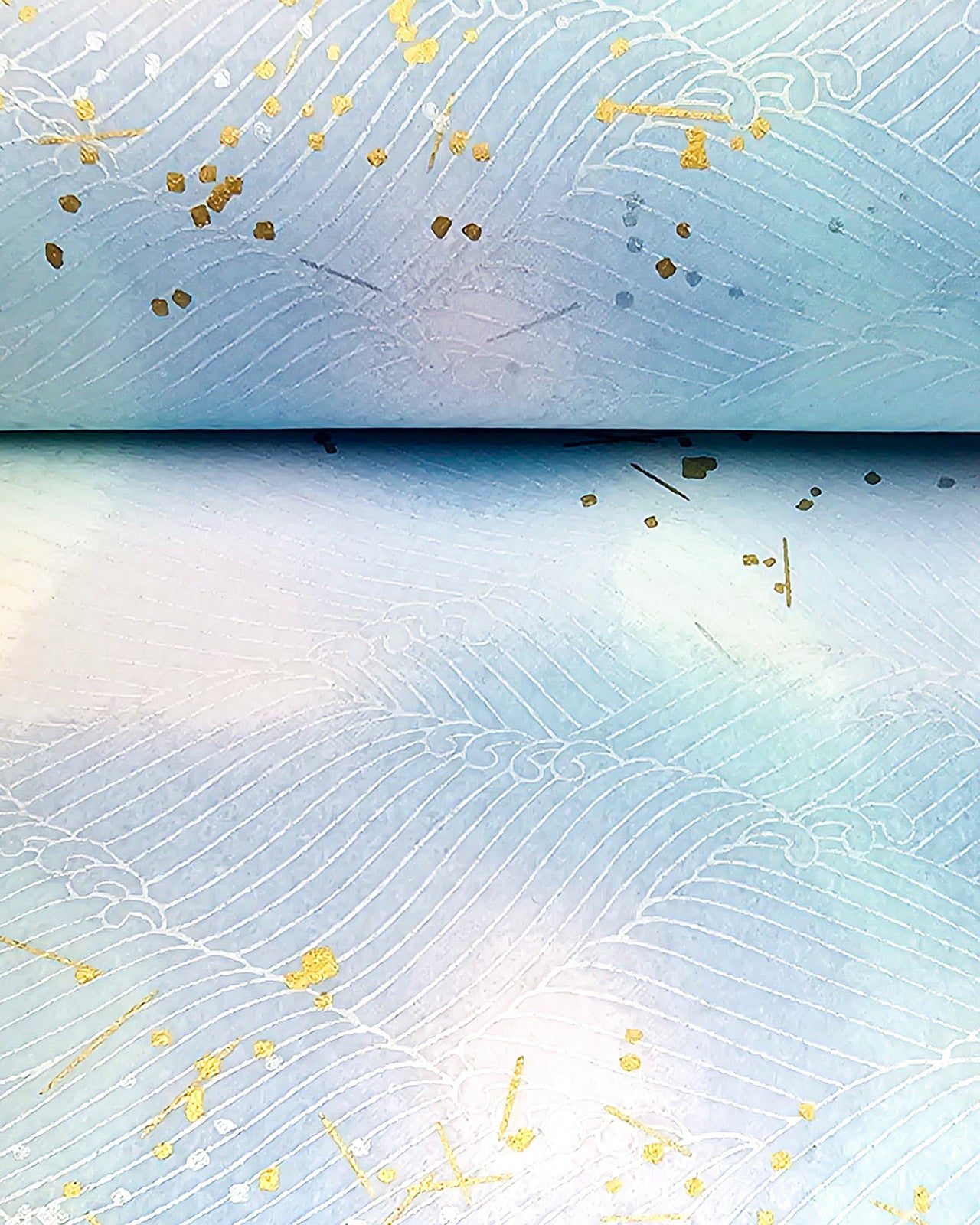 Japanese chiyogami paper featuring white waves on a blue & purple background with metallic gold and silver accents.