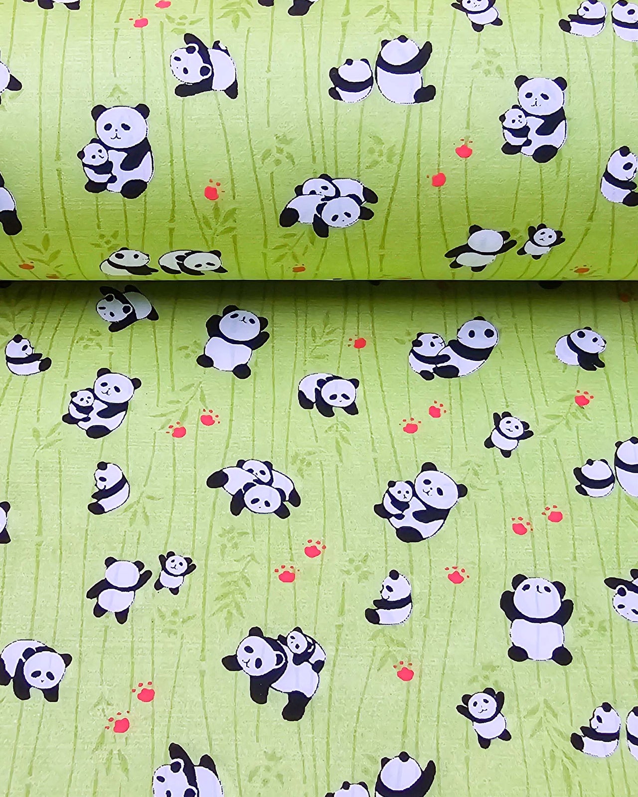 Japanese chiyogami featuring small pandas and small red paw prints on a green background with green bamboo.