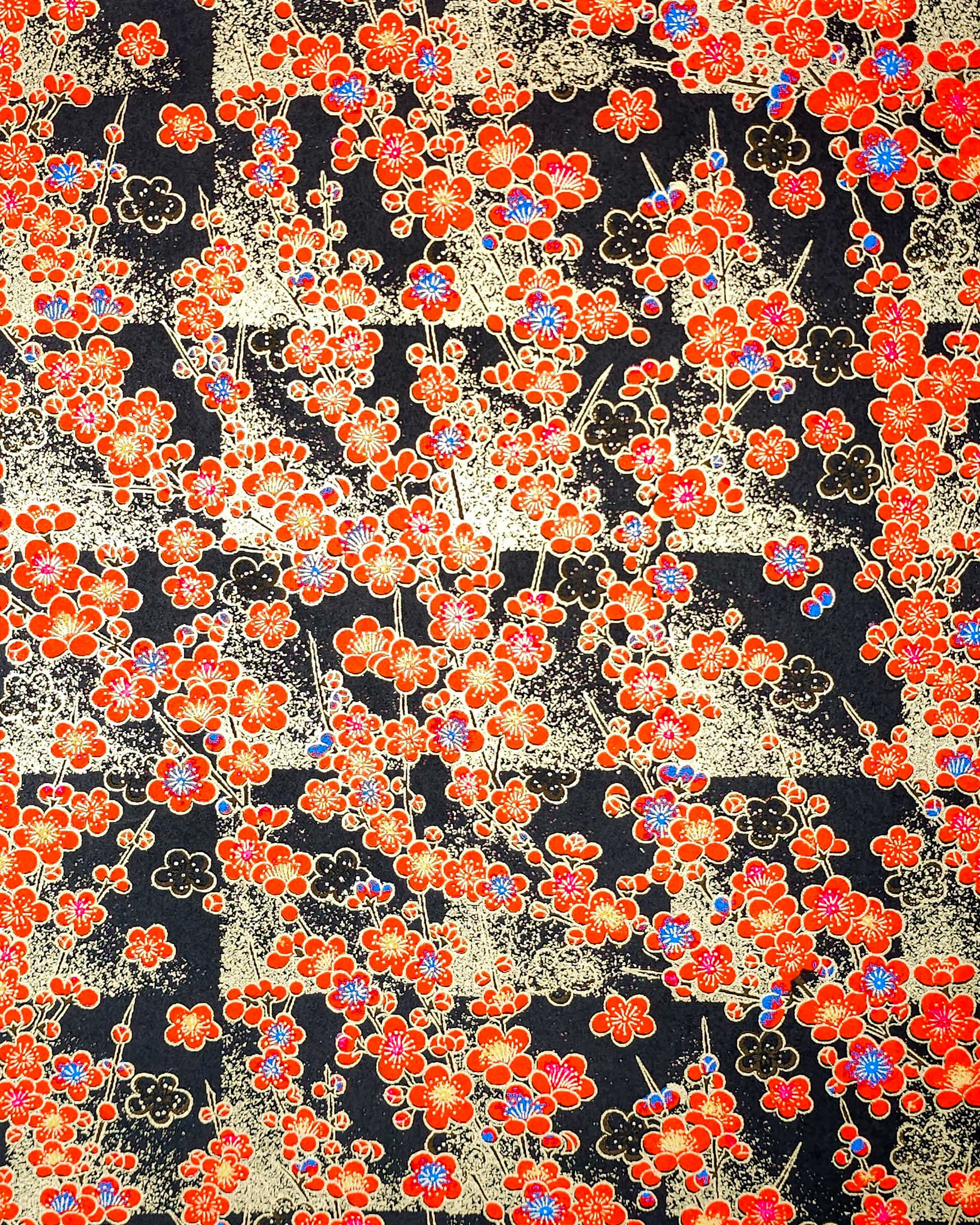 Japanese chiyogami featuring red plum blossoms with a little bit of blue on a black background with metallic gold accents.