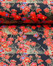 Japanese chiyogami featuring red plum blossoms with a little bit of blue on a black background with metallic gold accents.