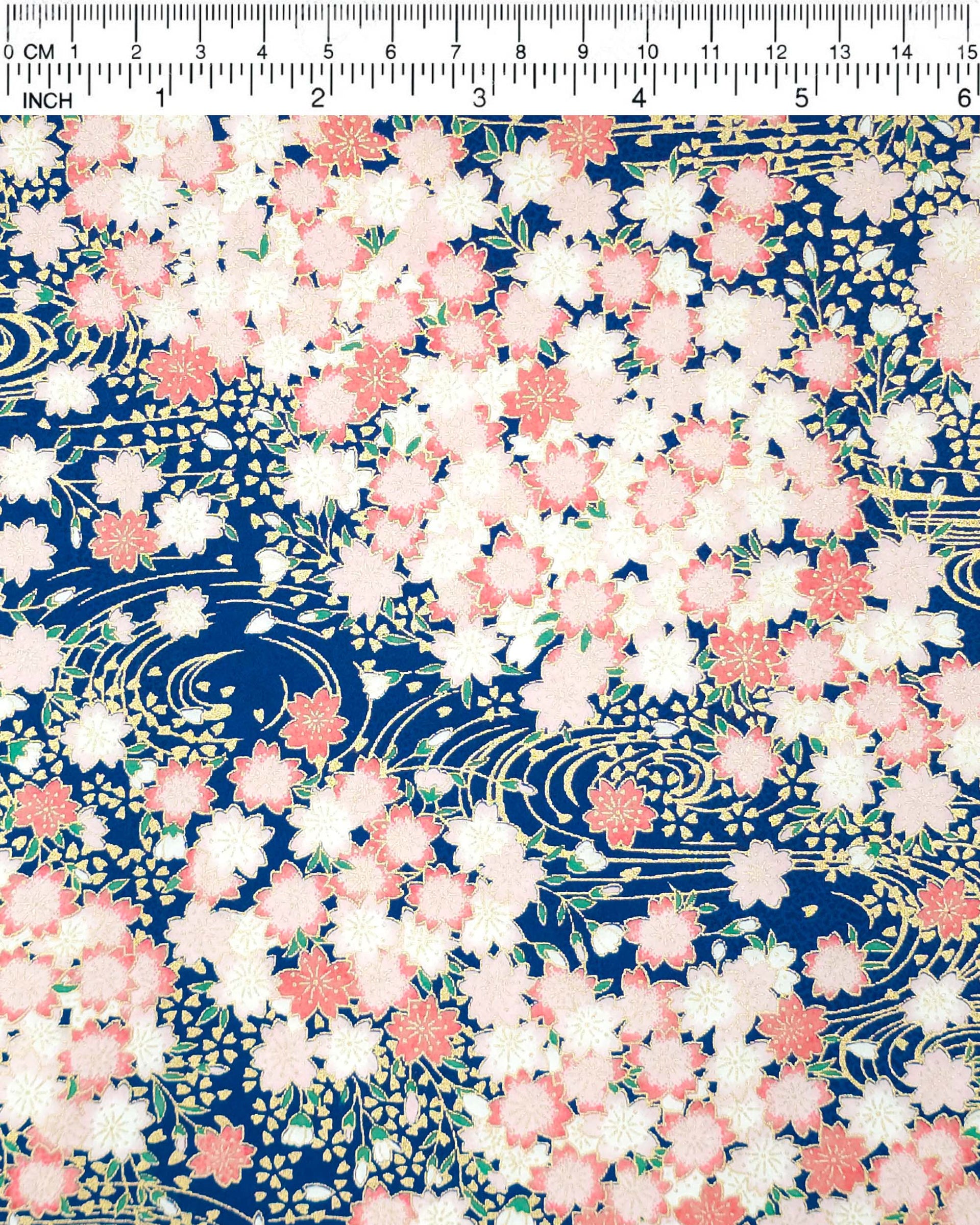 Japanese chiyogami featuring pink cherry blossoms on a blue background with metallic gold accents.