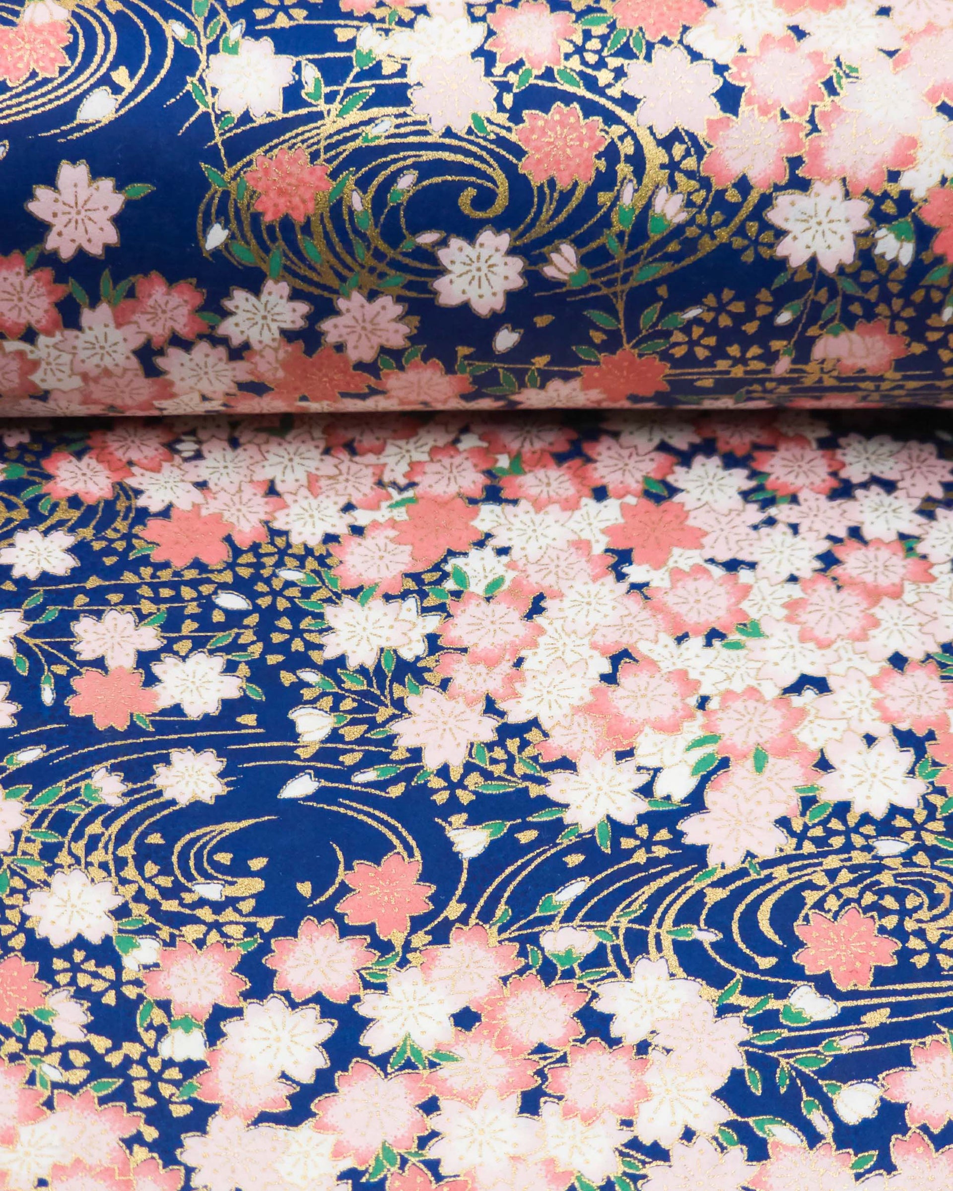 Japanese chiyogami featuring pink cherry blossoms on a blue background with metallic gold accents.