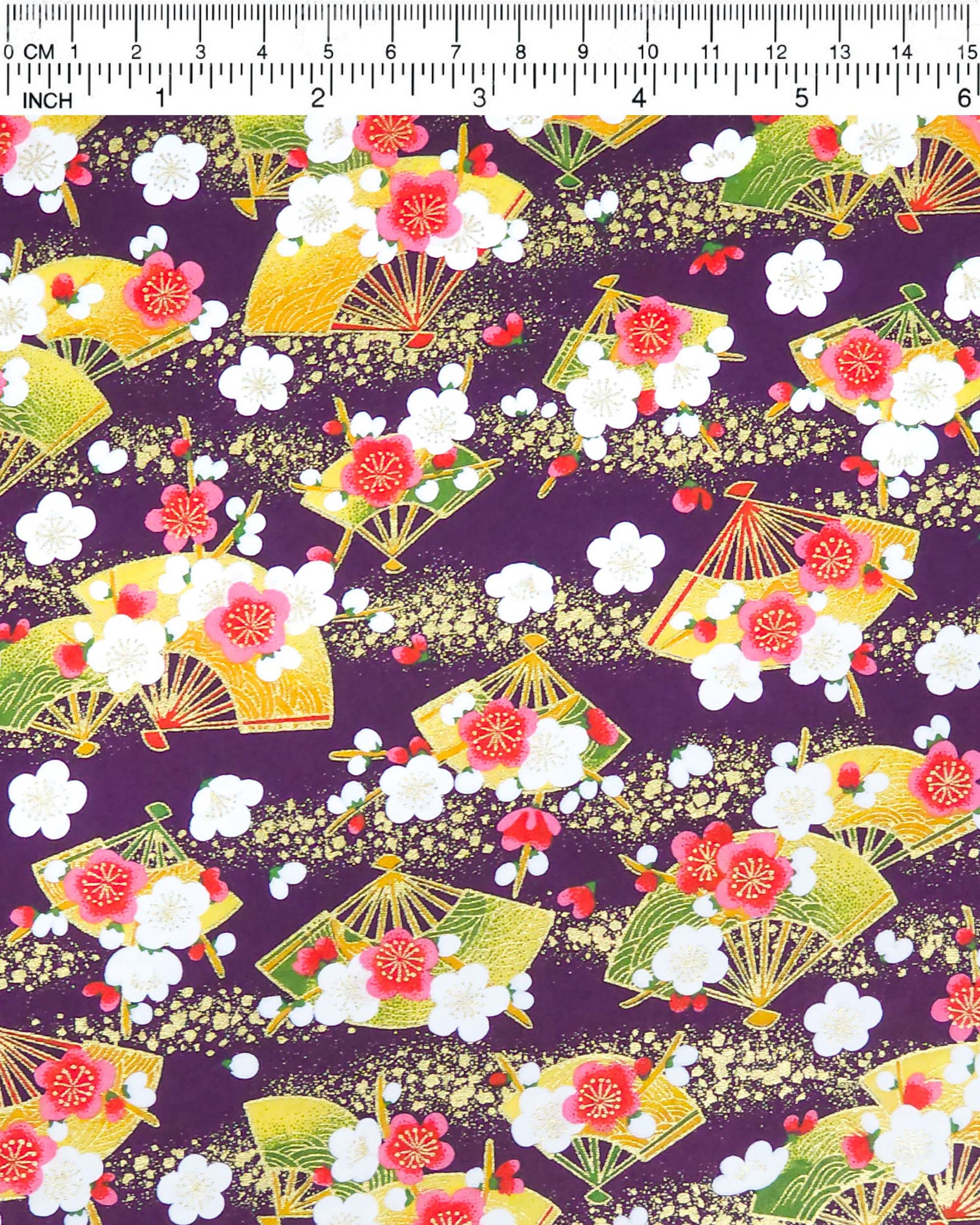 Japanese chiyogami paper featuring green & yellow hand fans with pink & white plum blossoms on a purple background with metallic gold accents.