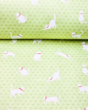 Japanese chiyogami featuring white cats with red collars on a green asanoha (hemp leaf) background.