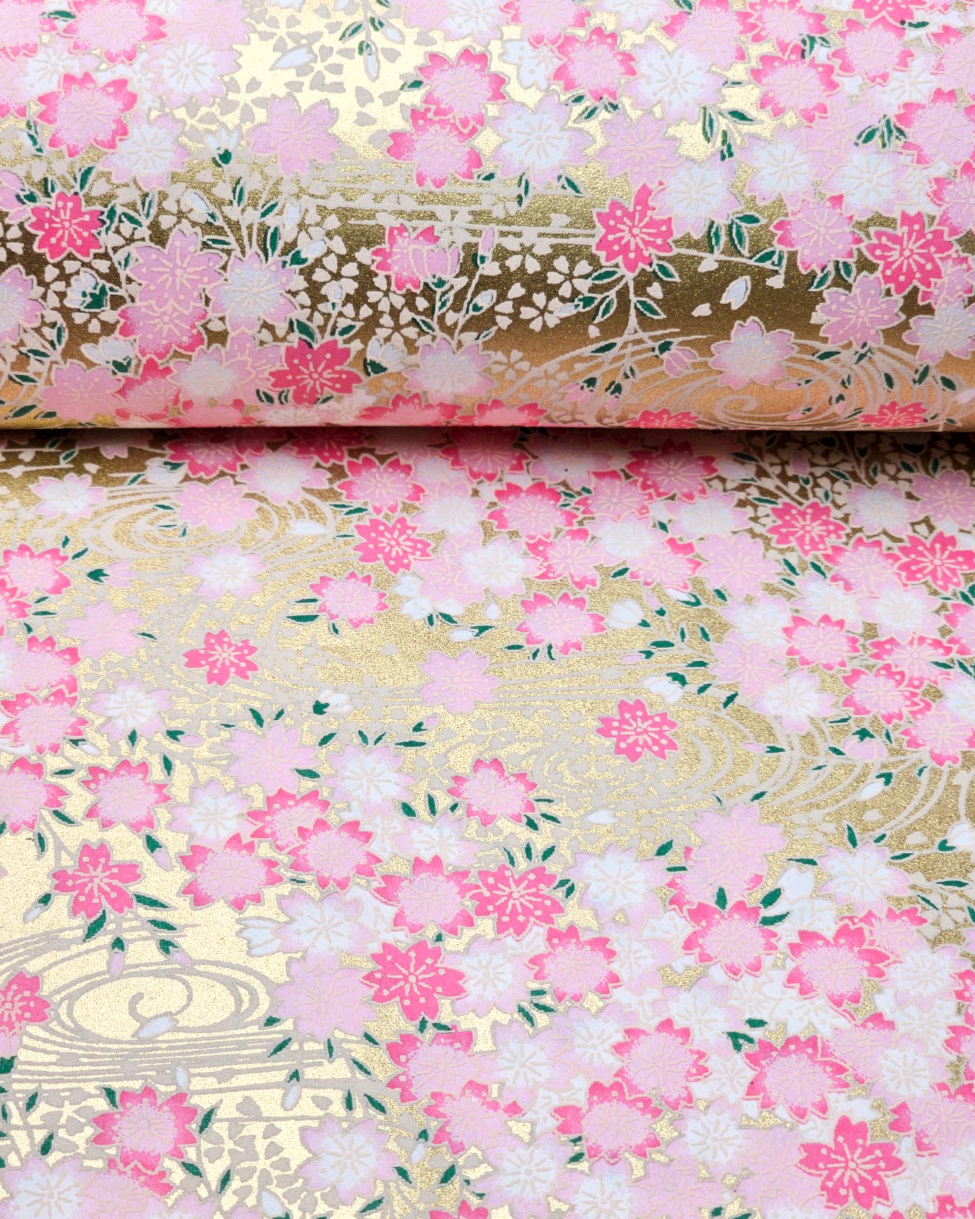 Japanese chiyogami paper featuring pink & white cherry blossoms on a metallic gold background.