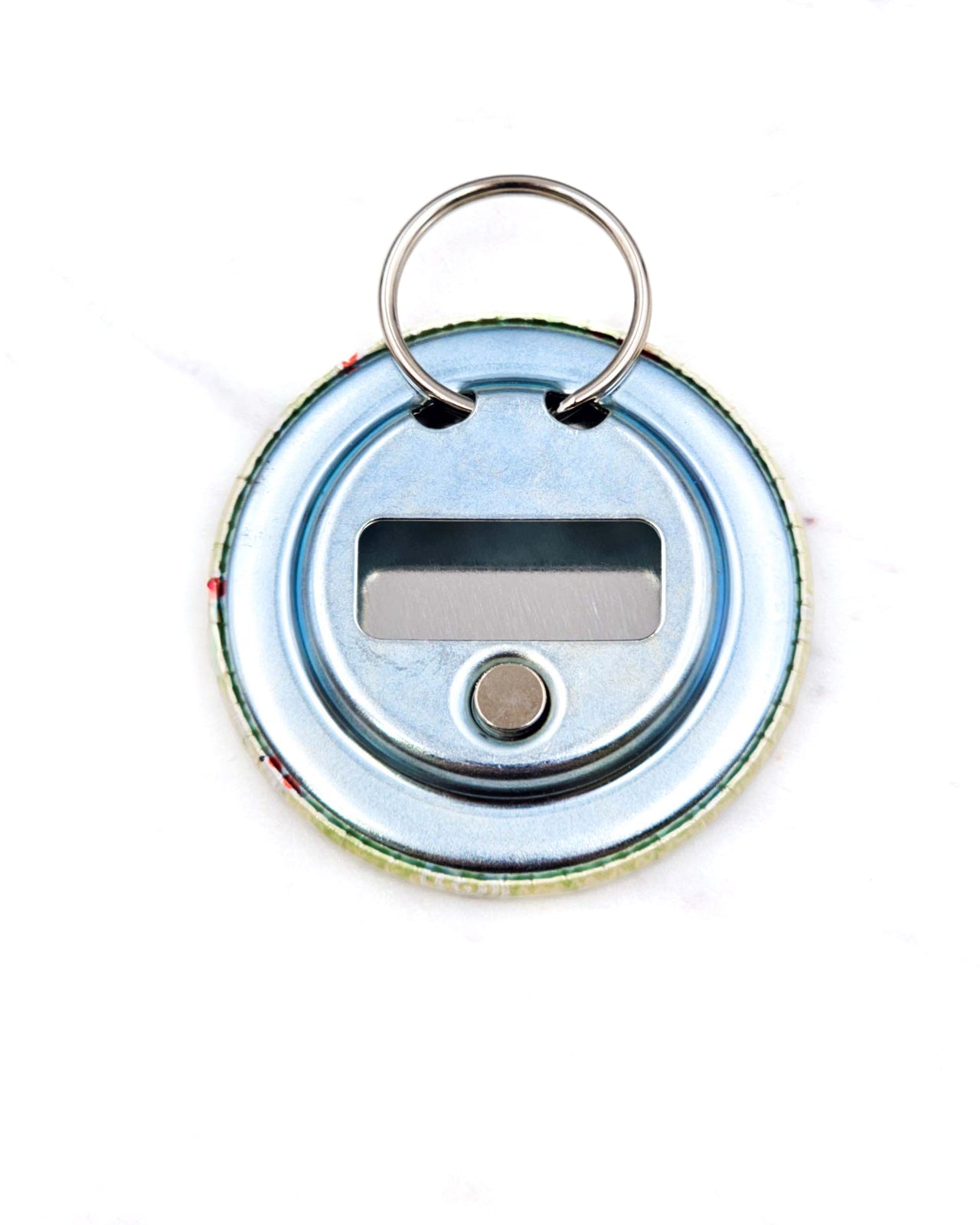 Magnetic bottle opener featuring red and white fishes on a green background.