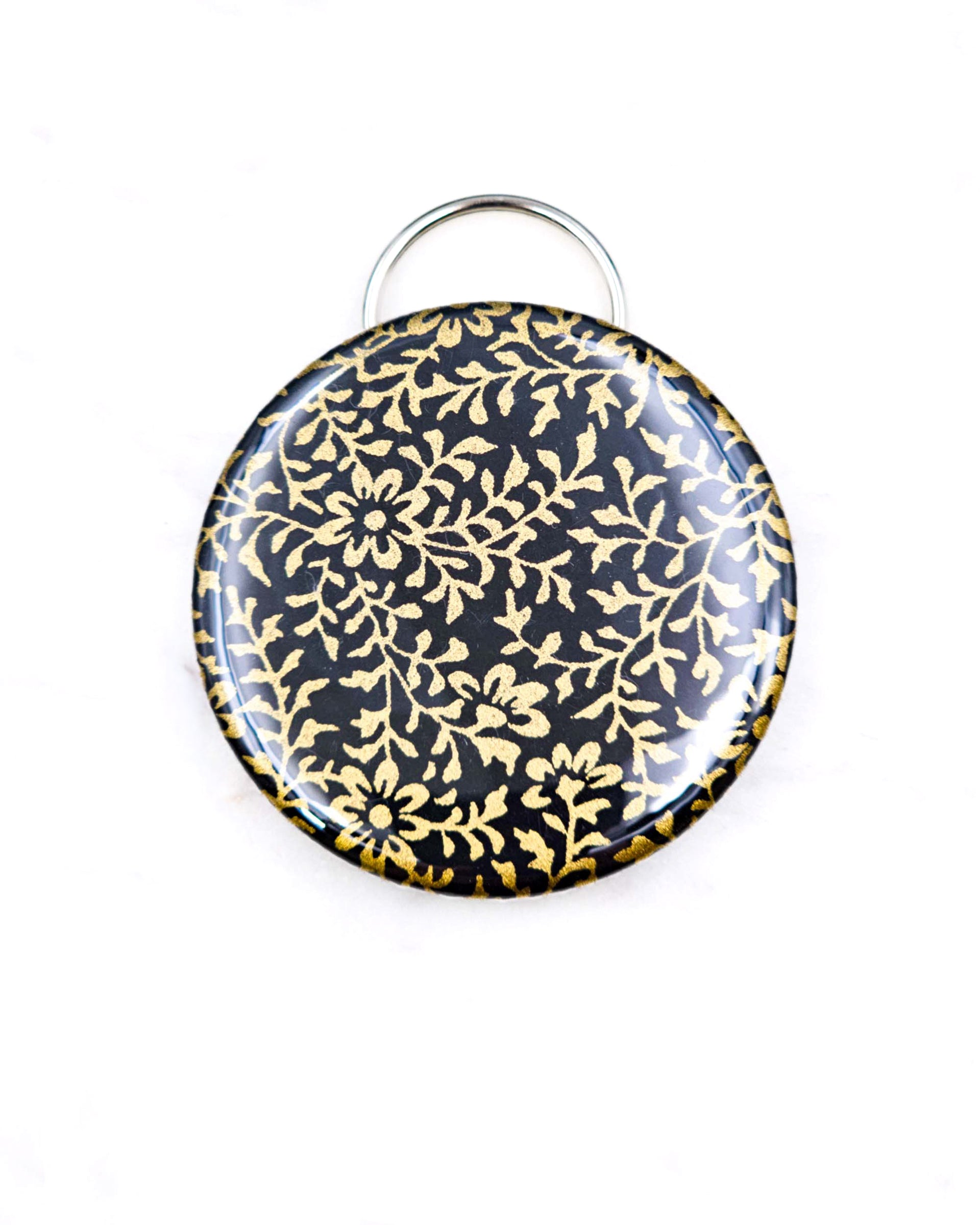 Magnetic bottle opener featuring a metallic gold floral design on a black background.