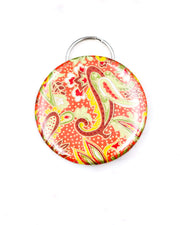 Magnetic bottle opener featuring a green and yellow paisley design on an orange background with metallic gold accents.
