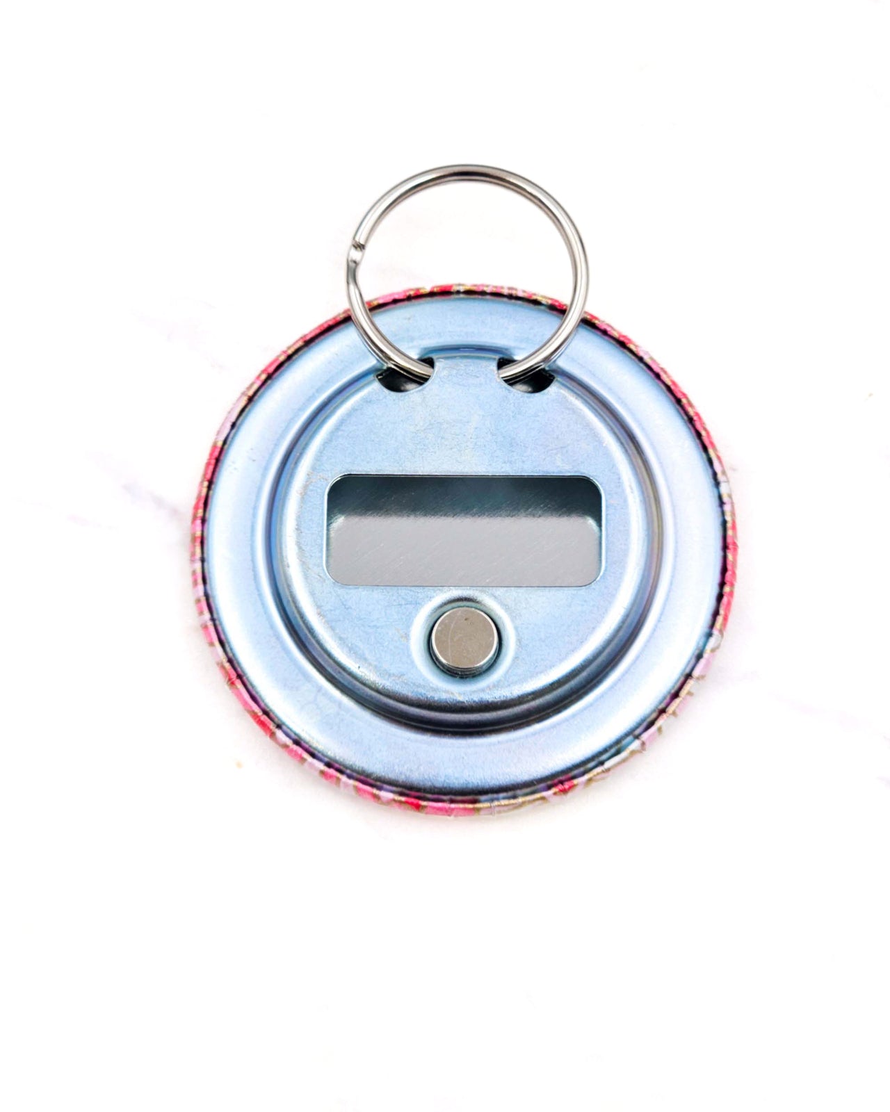 Magnetic bottle opener featuring pink and white abstract parasols with metallic gold accents