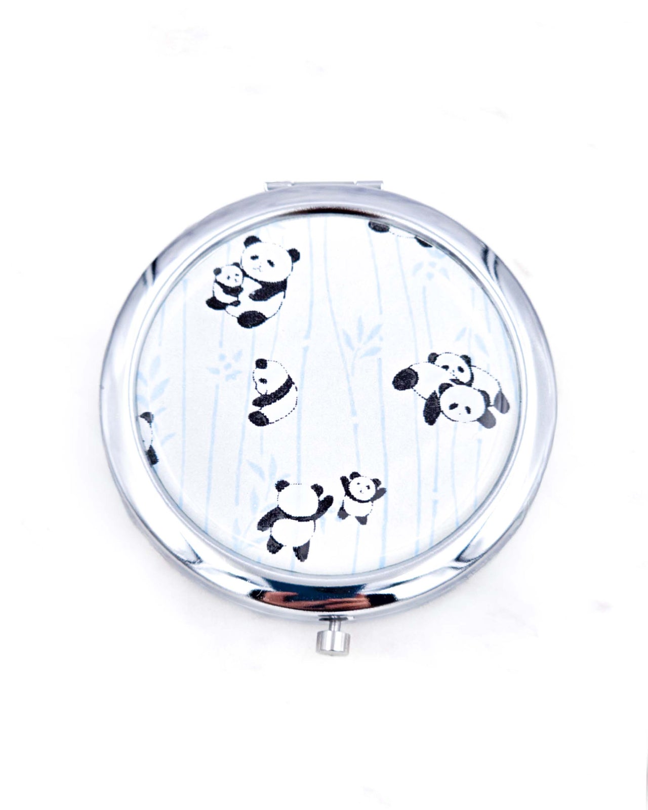 Silver metal compact mirror featuring pandas and blue bamboo on a pearlescent white background.