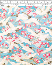 Japanese chiyogami paper featuring flying white cranes and pink cherry blossoms a light blue background with metallic gold accents.