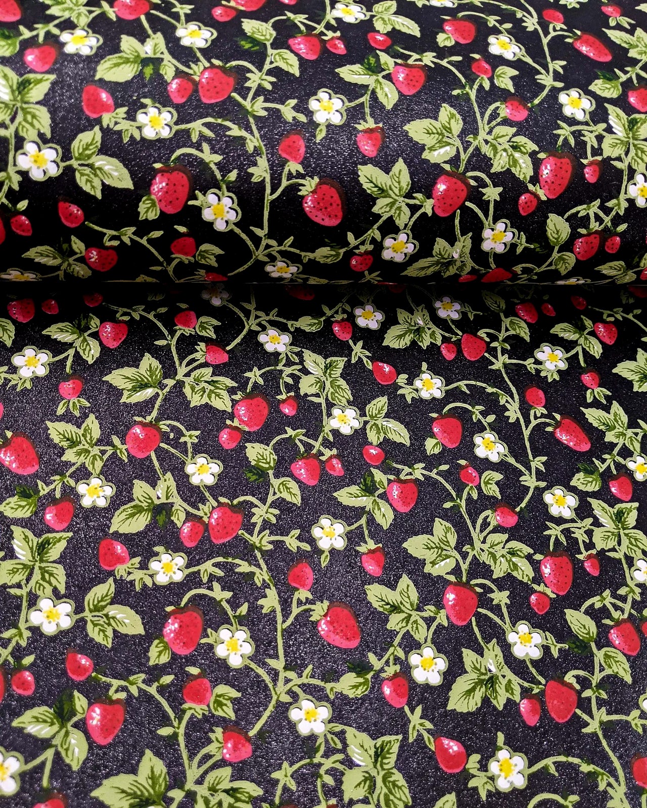 Japanese chiyogami paper featuring red strawberries with green leaves and white flowers on a glittery black background.