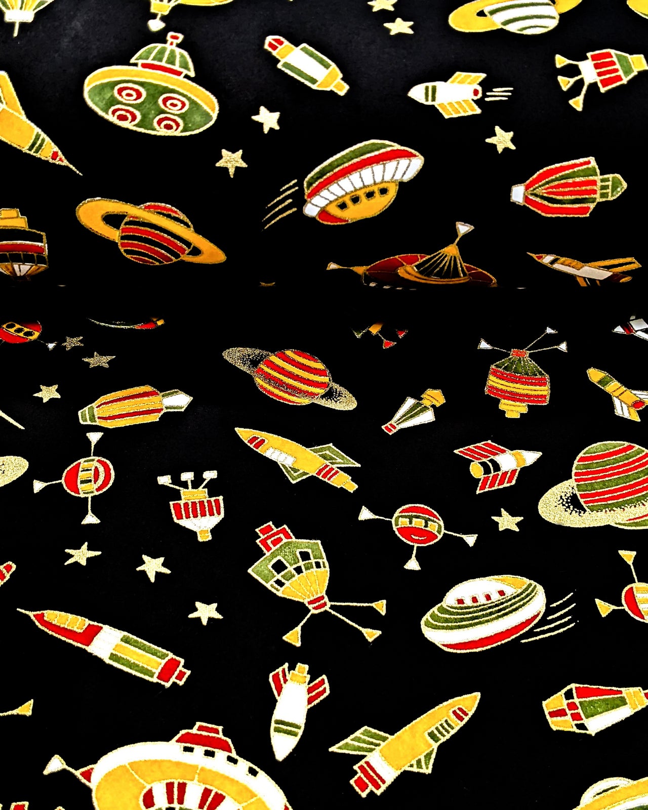 Japanese chiyogami paper featuring orange & red spaceships & planets on a black background with metallic gold accents.