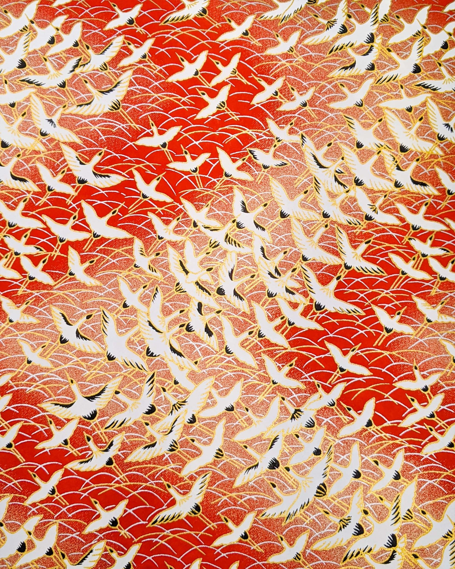 Japanese chiyogami featuring flying white cranes zigzagging on a gold & red background with metallic gold accents.