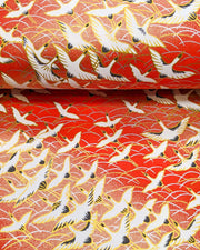 Japanese chiyogami featuring flying white cranes zigzagging on a gold & red background with metallic gold accents.