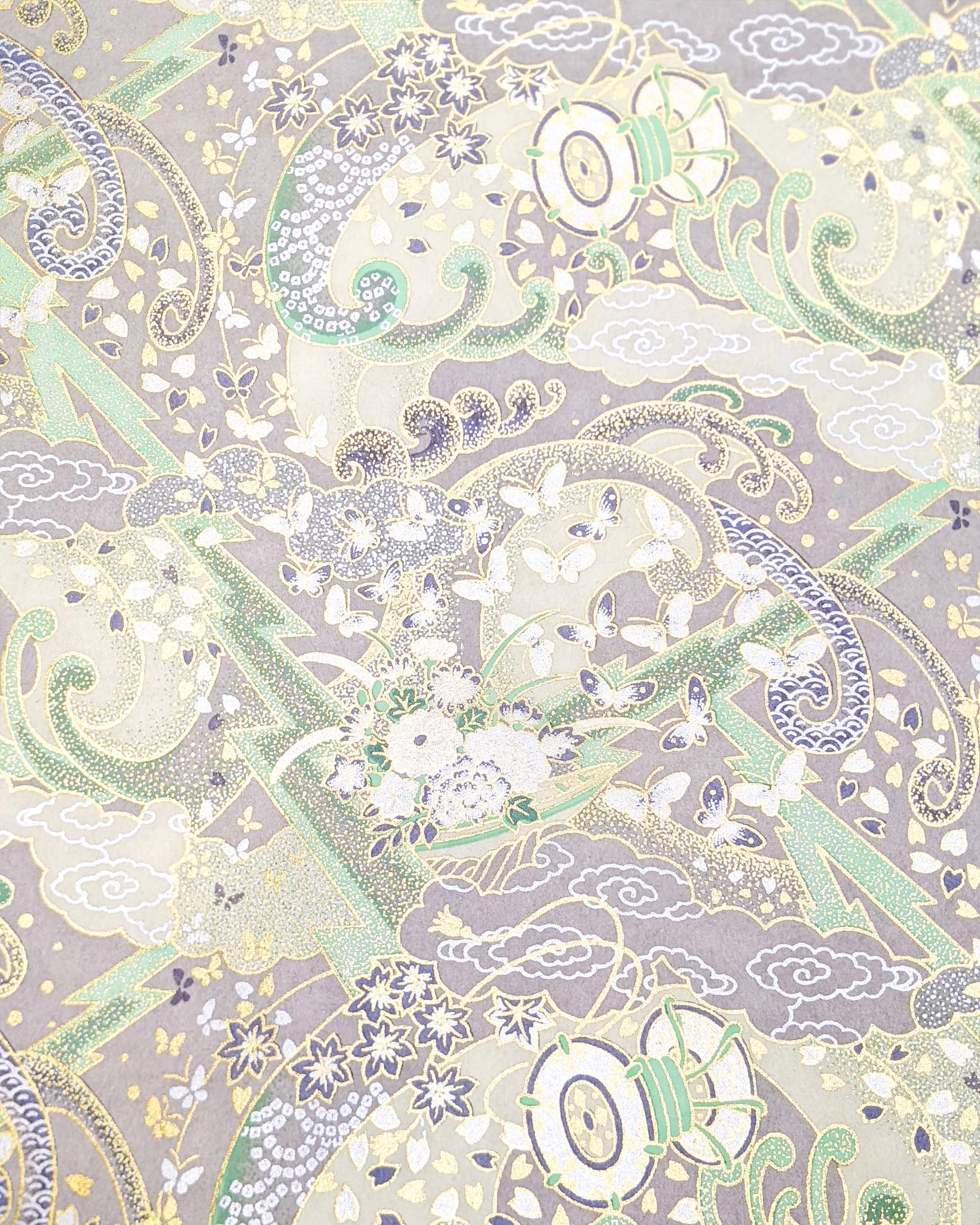 Japanese chiyogami paper featuring a light gray and turquoise stormy seascape with lightning, butterflies, and floral boats with metallic gold and silver accents.