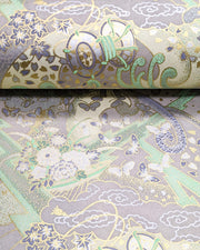 Japanese chiyogami paper featuring a light gray and turquoise stormy seascape with lightning, butterflies, and floral boats with metallic gold and silver accents.