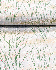 Japanese chiyogami paper featuring small white flower bushes over a light blue background with metallic gold accents.