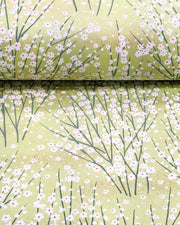 Japanese chiyogami paper featuring small white flower bushes over a yellow green background with metallic gold accents.