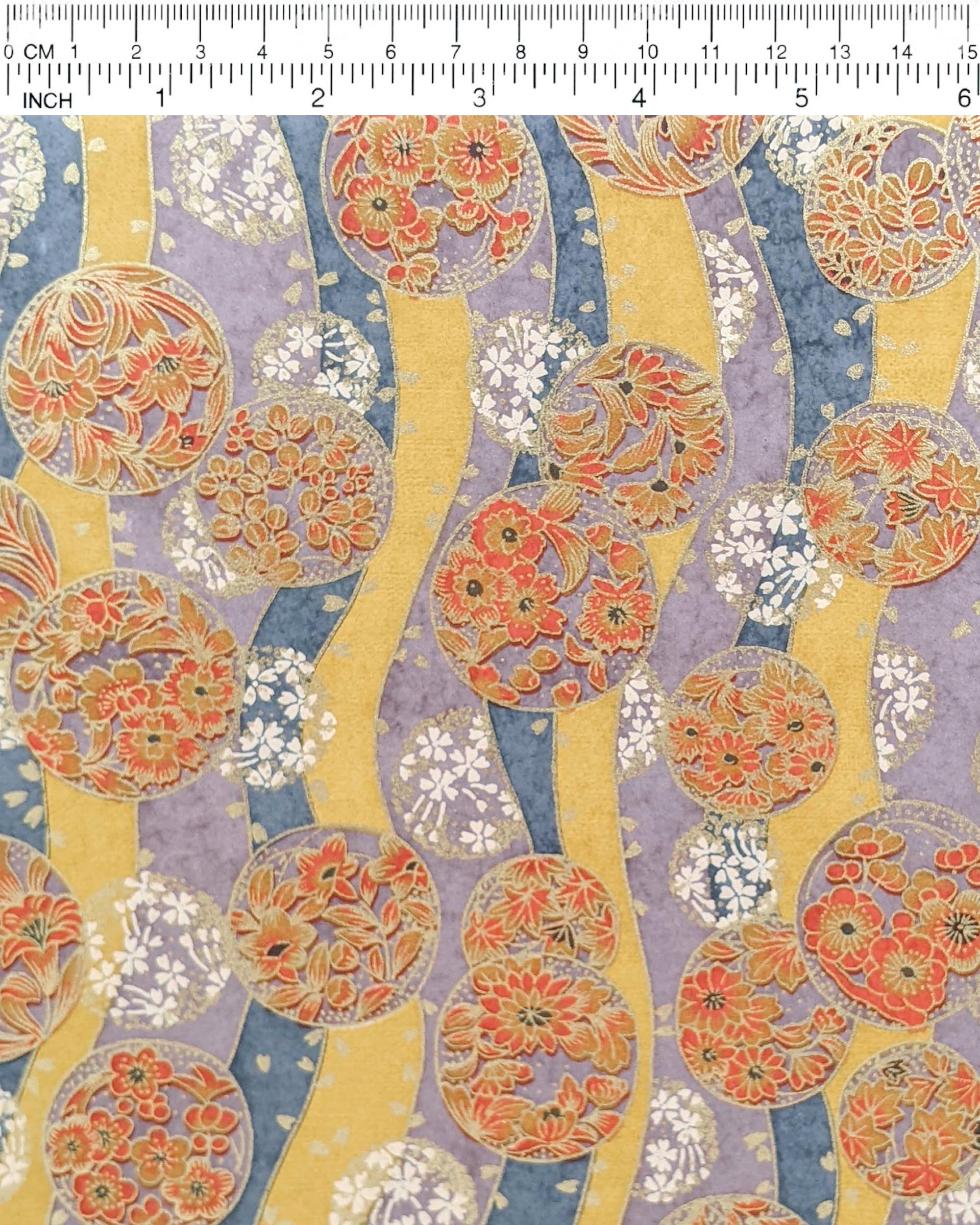 Japanese chiyogami paper featuring purple & orange floral temari balls on a blue, purple, and light orange background with metallic gold accents.