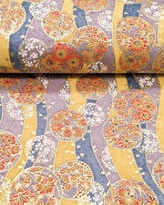 Japanese chiyogami paper featuring purple & orange floral temari balls on a blue, purple, and light orange background with metallic gold accents.