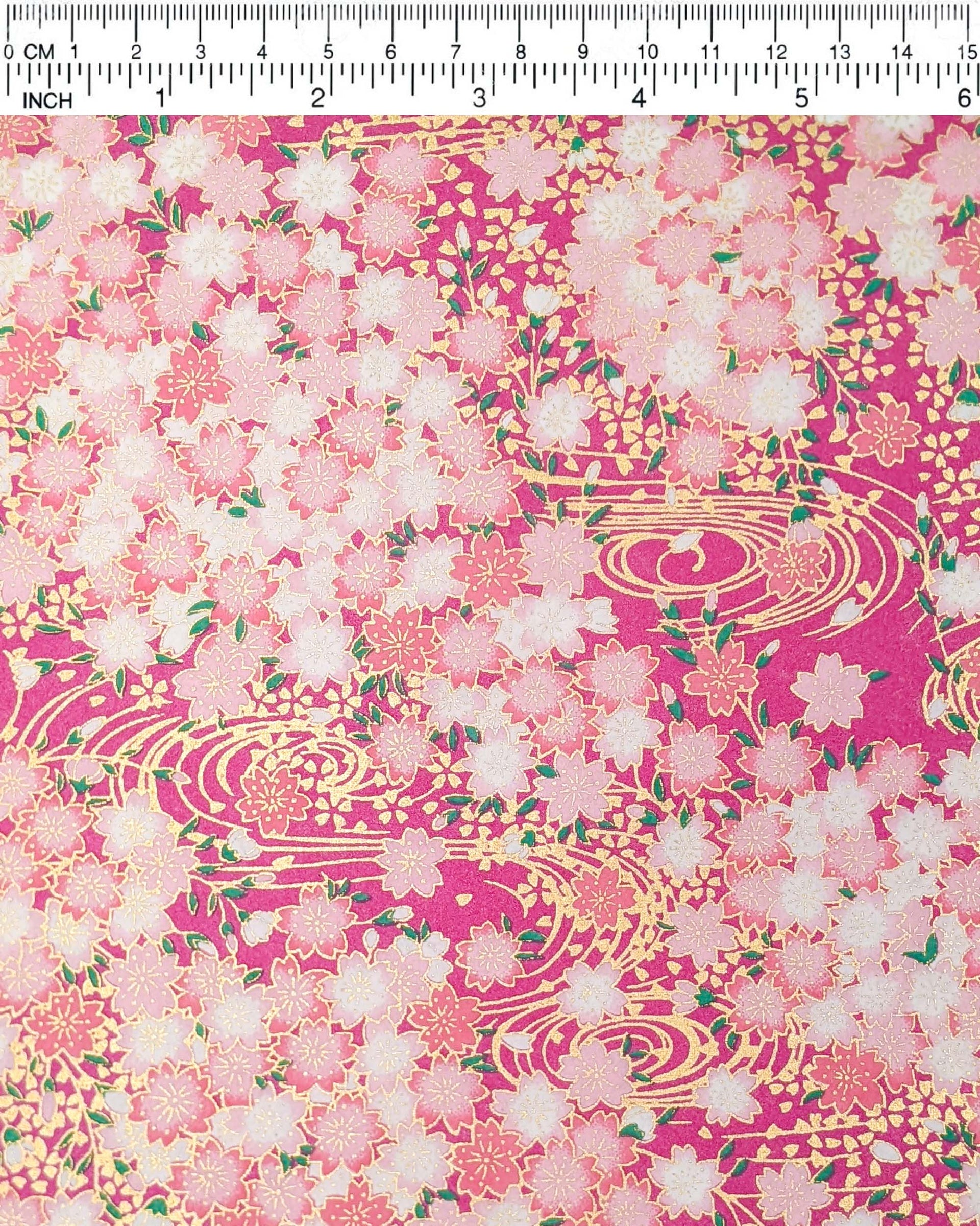 Japanese chiyogami paper featuring pink and white cherry blossoms on a pearlescent pink background with metallic gold accents.