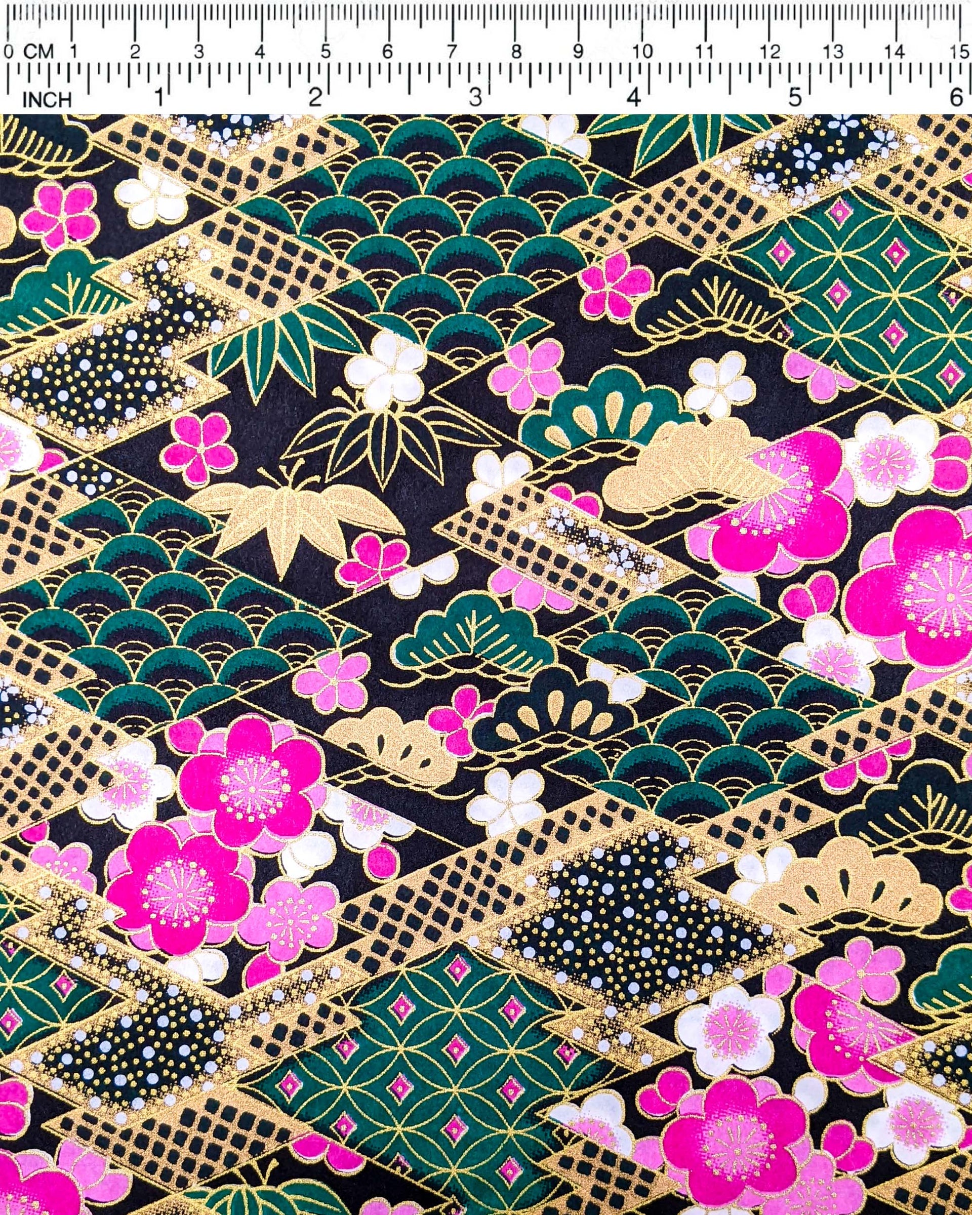 Japanese chiyogami paper featuring pink & white plum blossoms on a black & green background with metallic gold accents.