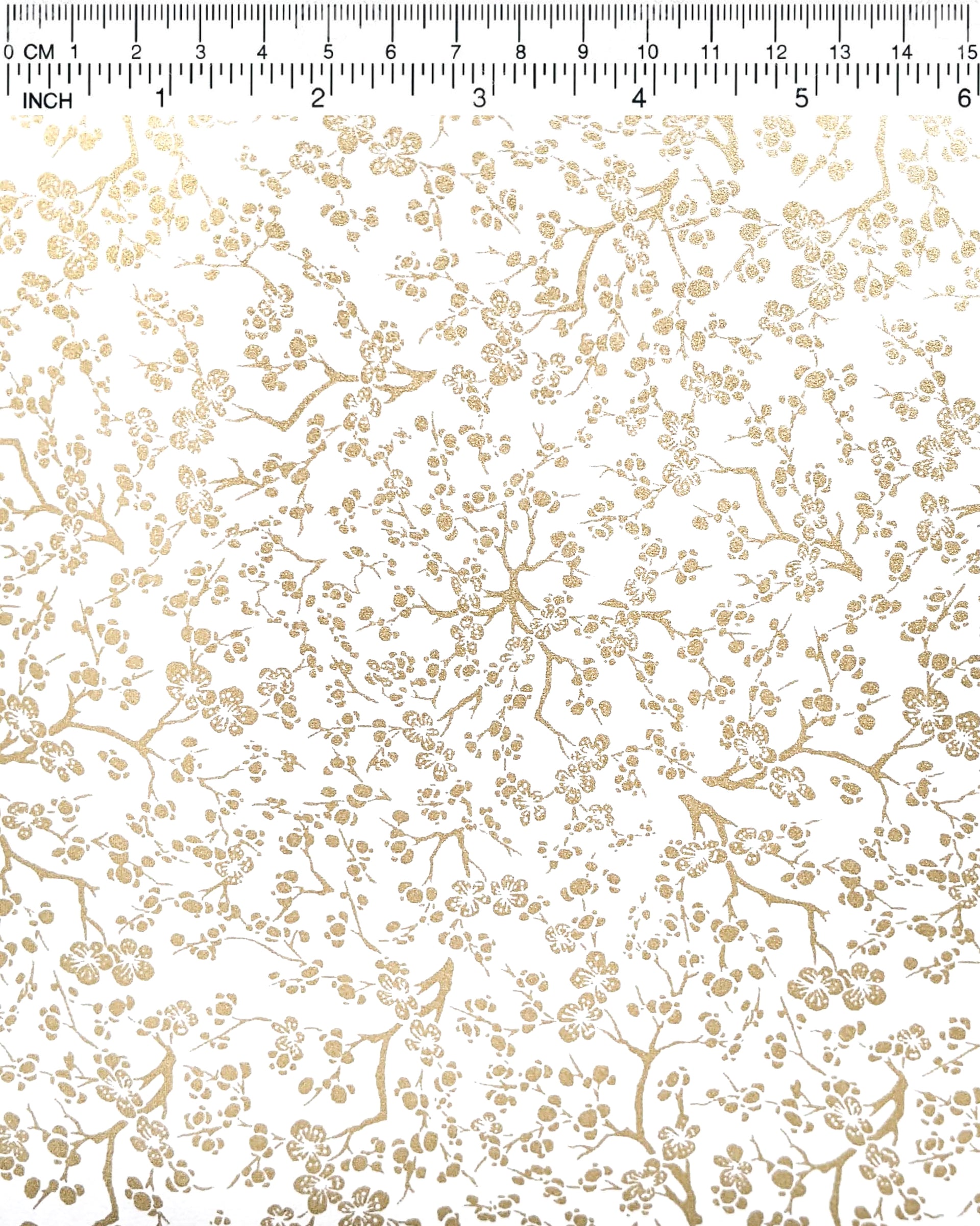 Japanese chiyogami paper featuring small metallic gold plum blossom branches on a white background.