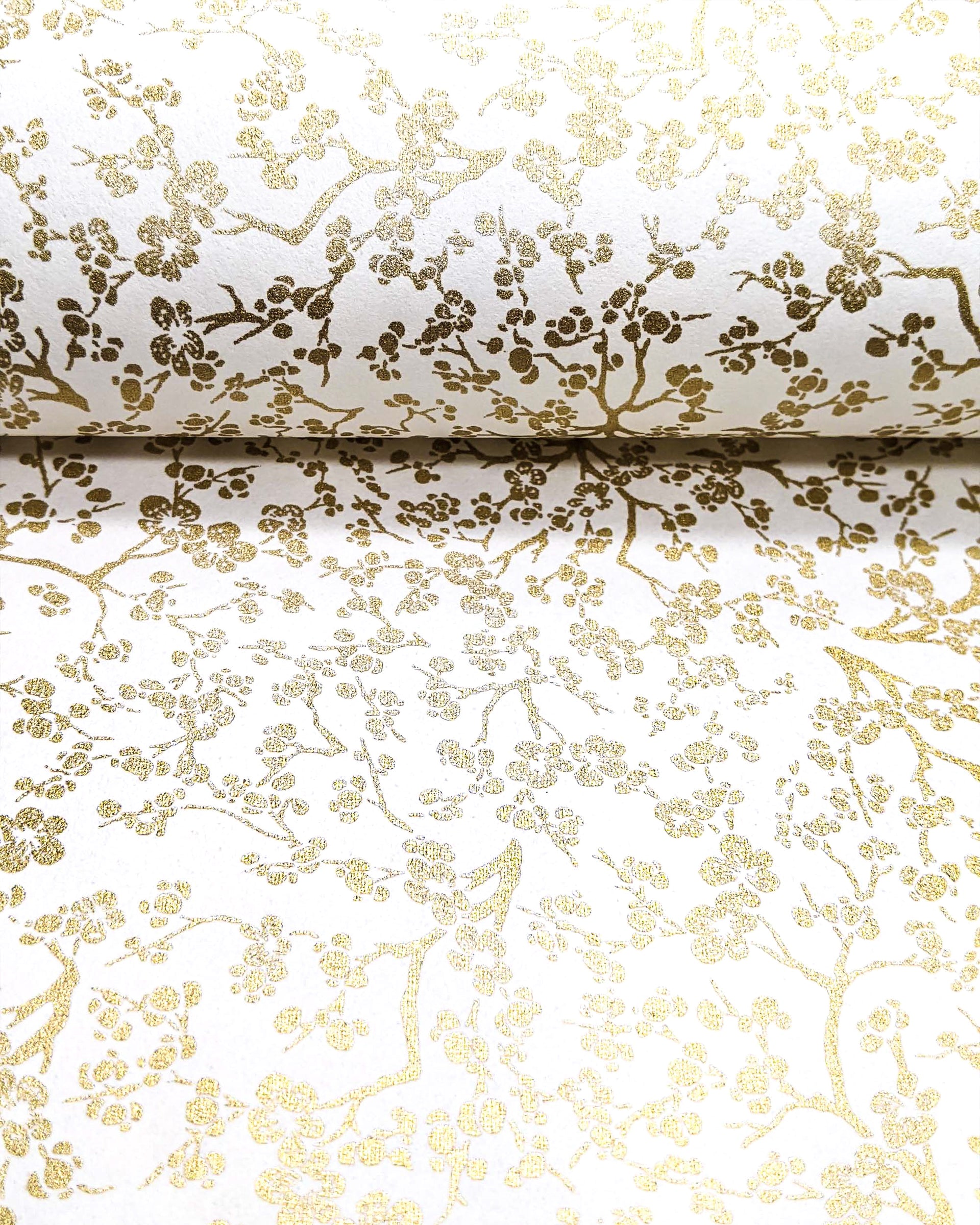 Japanese chiyogami paper featuring small metallic gold plum blossom branches on a white background.