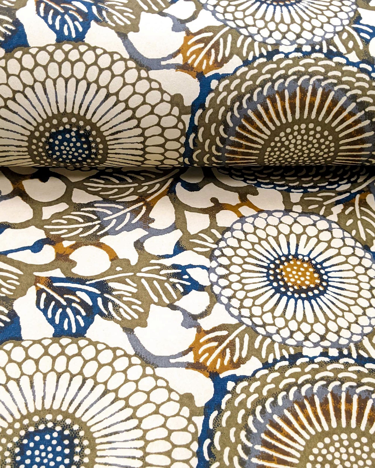 Japanese chiyogami paper featuring large blue and green zinnia flowers with orange accents on a beige background.