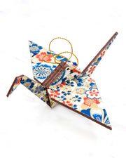 Large wooden origami crane ornament featuring red, white, and blue cherry blossoms with metallic gold details.
