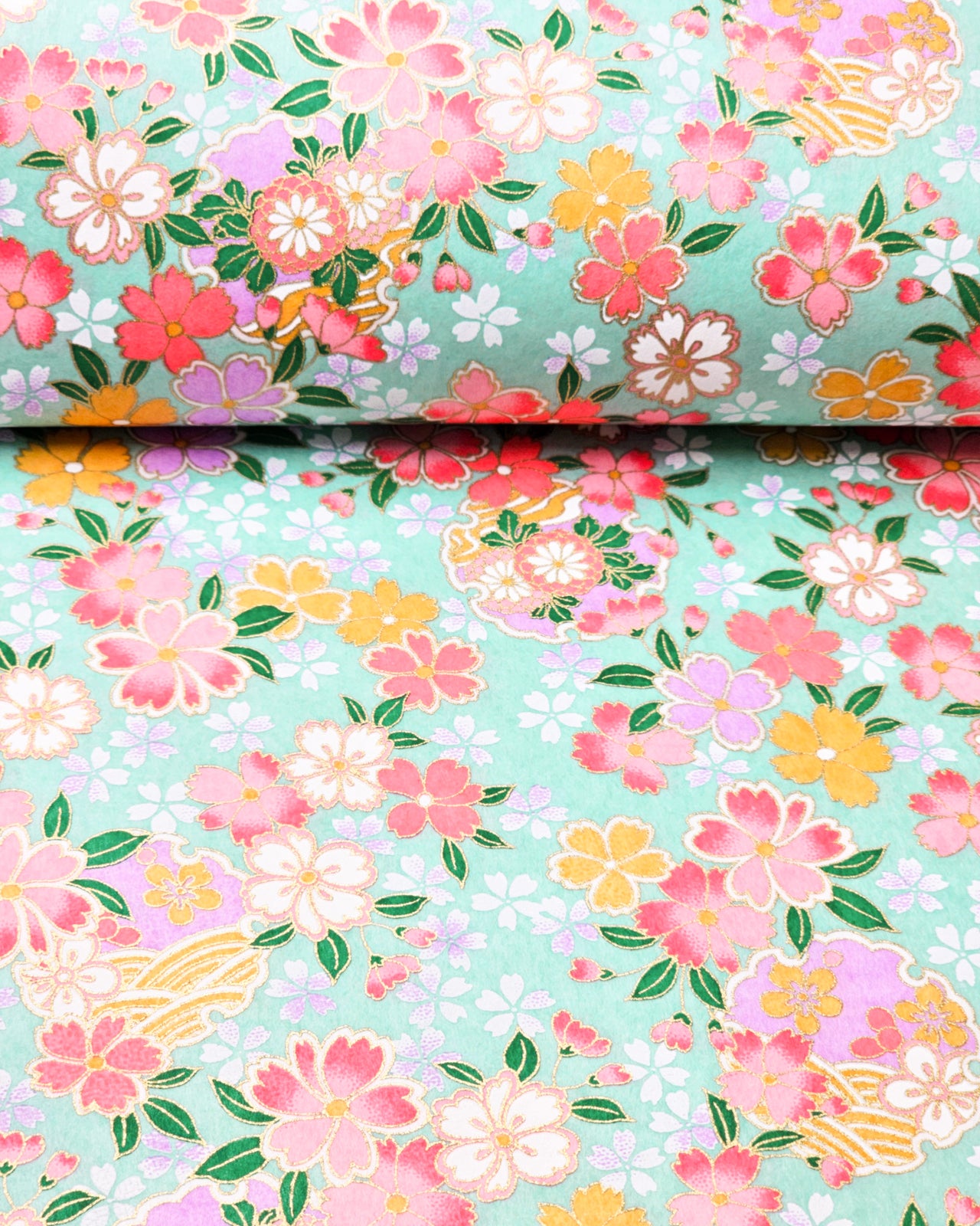 Japanese chiyogami paper featuring pink, yellow, purple, and white cherry blossoms and purple yukiwas on a turquoise background with metallic gold accents.