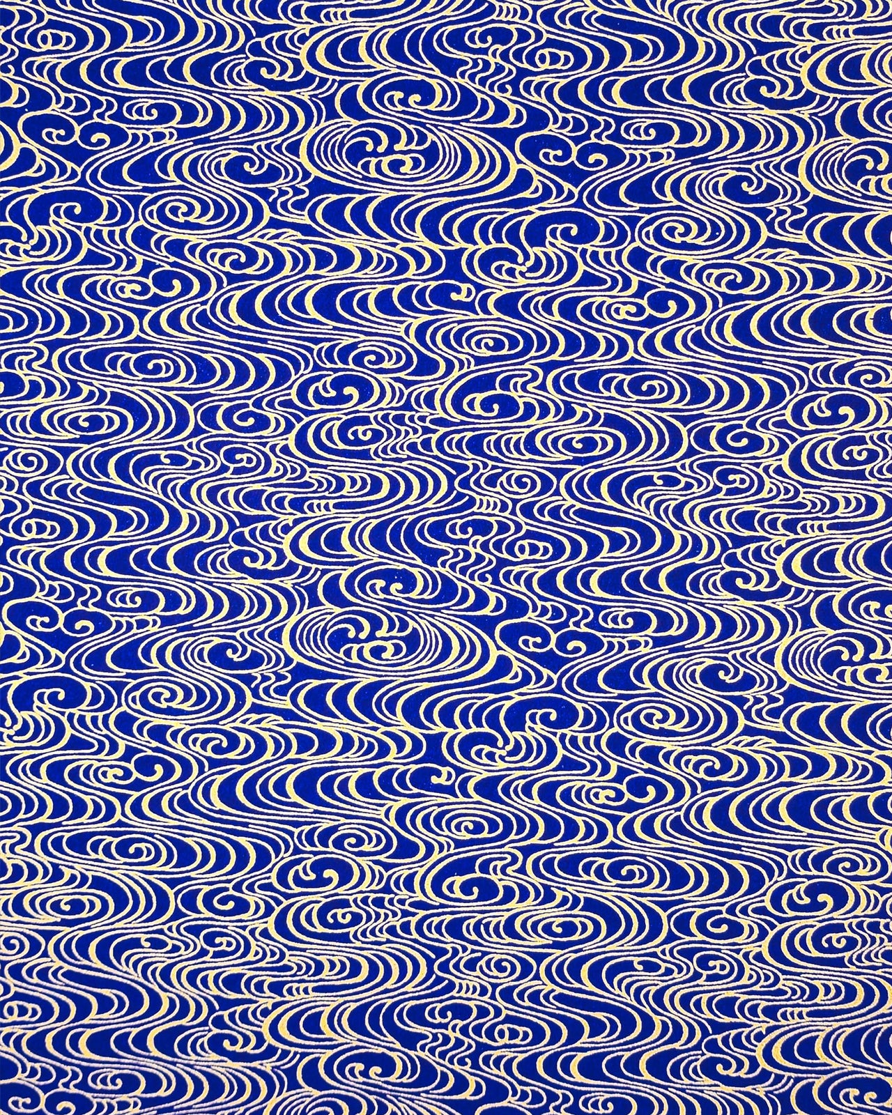 Japanese chiyogami paper featuring metallic gold water ripples on a dark blue background