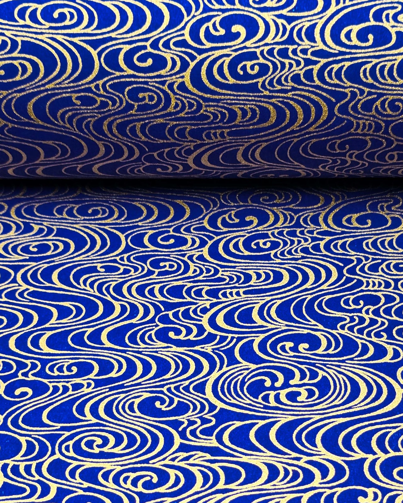 Japanese chiyogami paper featuring metallic gold water ripples on a dark blue background
