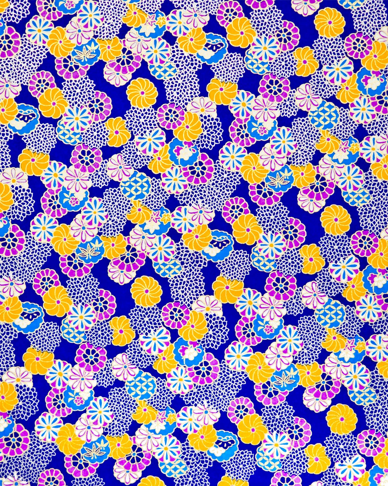 Japanese chiyogami paper featuring an assortment of blue, purple, orange, and silver flowers on a dark blue background with metallic gold accents