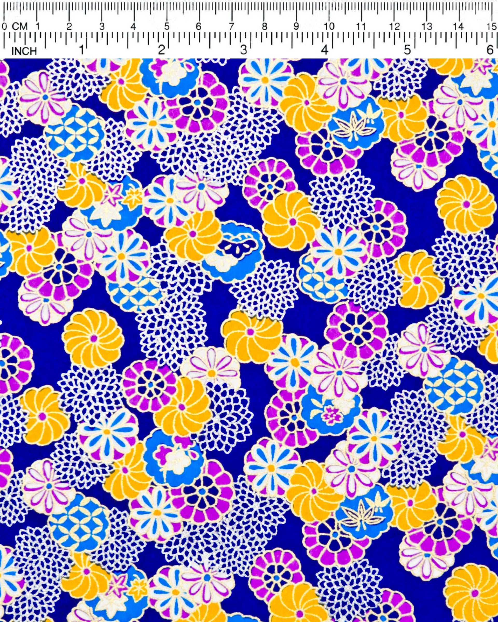 Japanese chiyogami paper featuring an assortment of blue, purple, orange, and silver flowers on a dark blue background with metallic gold accents