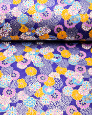 Japanese chiyogami paper featuring an assortment of blue, purple, orange, and silver flowers on a dark blue background with metallic gold accents