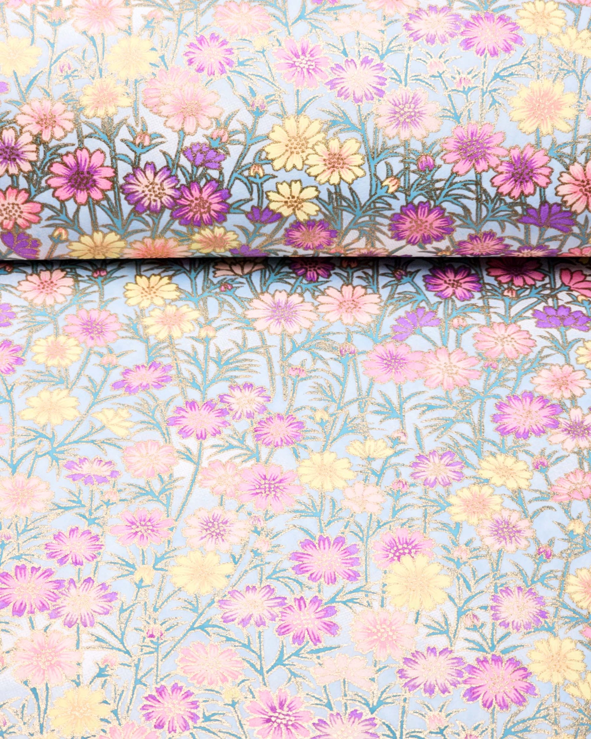 Japanese chiyogami paper featuring purple, pink, and yellow flower stalks on a light blue background with metallic gold accents